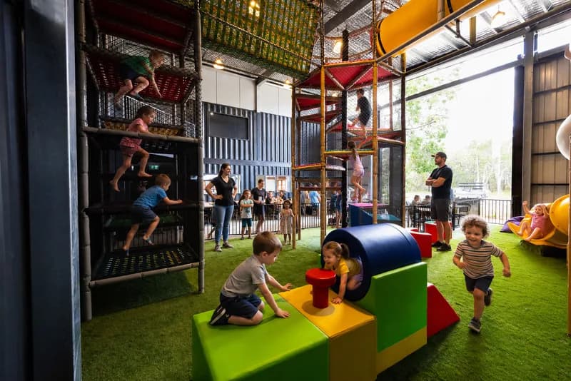 Kids at the table beside the Playpen nets