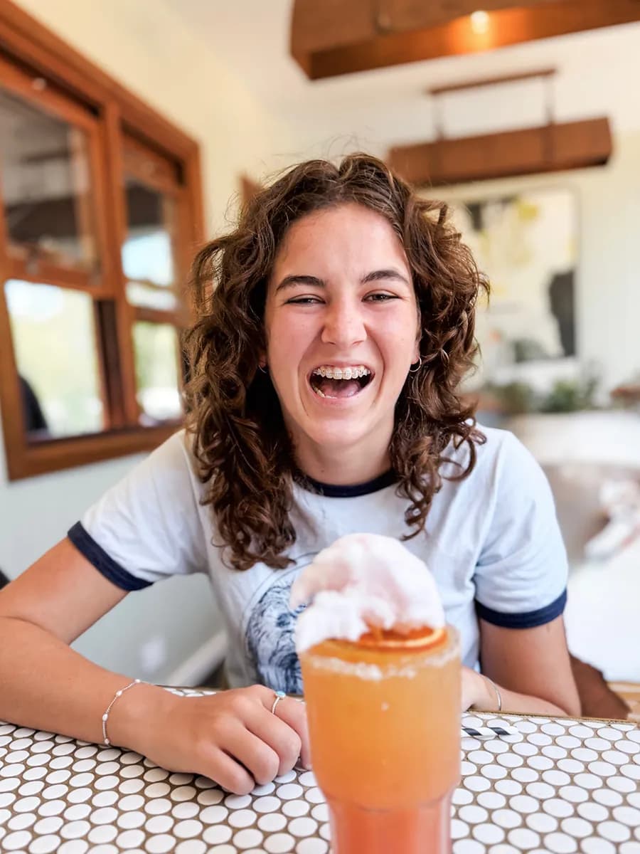 A guest laughing over a frozen cocktail at The 383