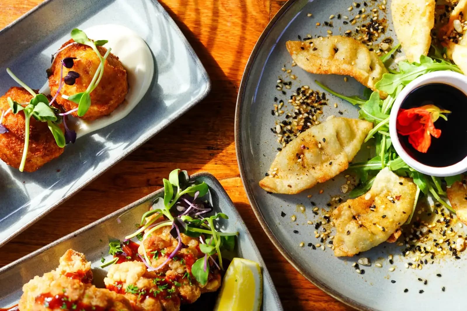 Arancini, gyoza and sharing plates on a timber table at The 383